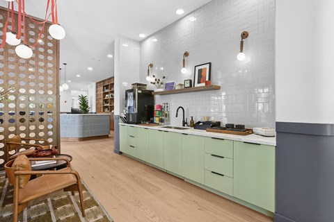 A kitchen with green cabinets and a wooden chair.