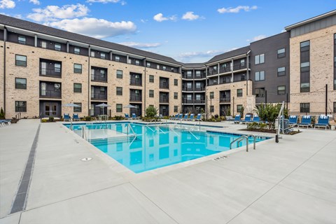 A large swimming pool is surrounded by apartment buildings.