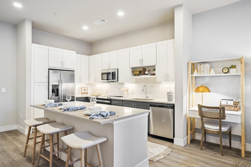 a kitchen with a bar and a dining area with stools