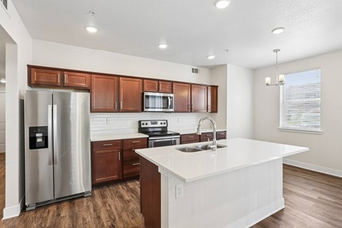 A modern kitchen with a white island and stainless steel appliances.