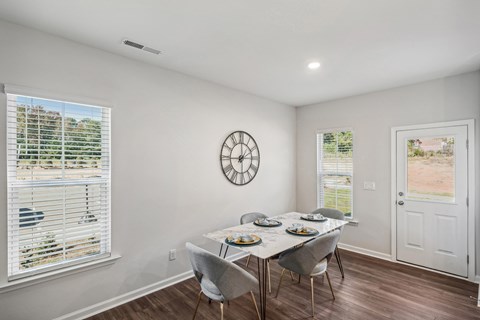 Furnished dining room with ample natural lighting inside a townhome at Porchlight Brier Creek