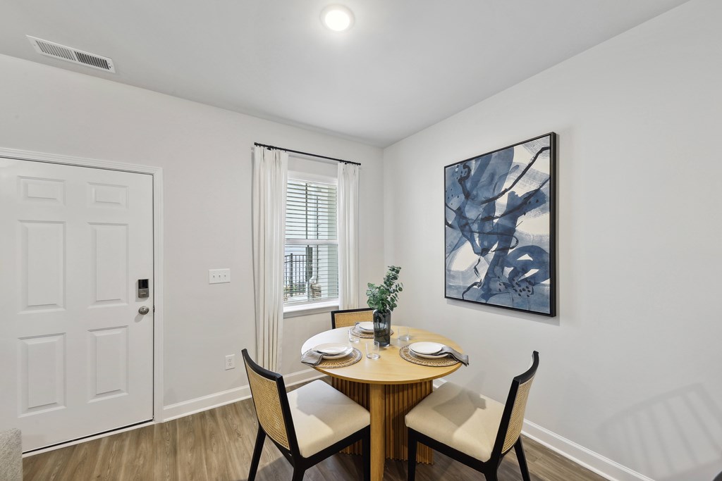 a dining room with a table and chairs and a window
