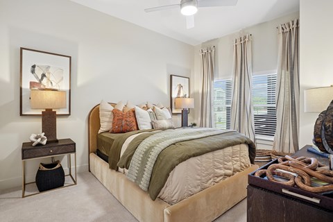 A bedroom with a large bed and a painting on the wall.