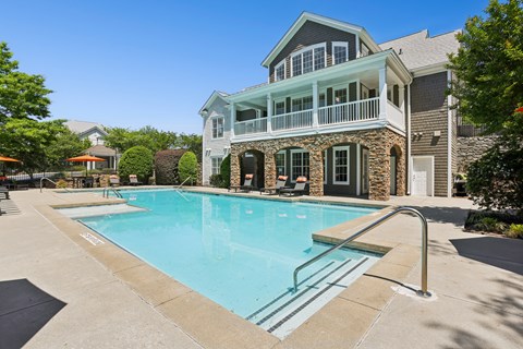 A large house with a pool in front.
