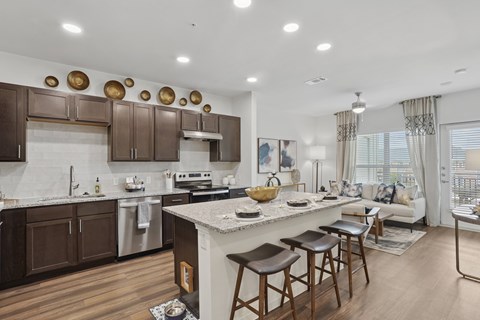 A modern kitchen with brown cabinets and a white island.