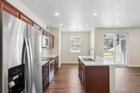 A modern kitchen with a stainless steel refrigerator and wooden cabinets.