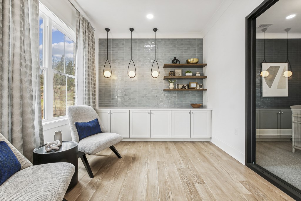 a living room with two chairs and a table and a window