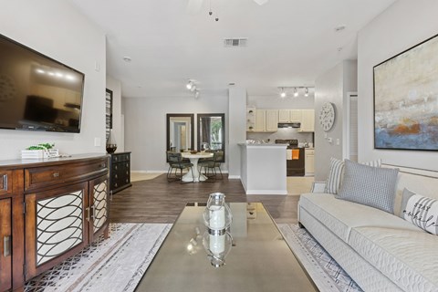 A modern living room with a white sofa and a wooden cabinet.