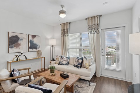 A living room with a white couch and a wooden coffee table.
