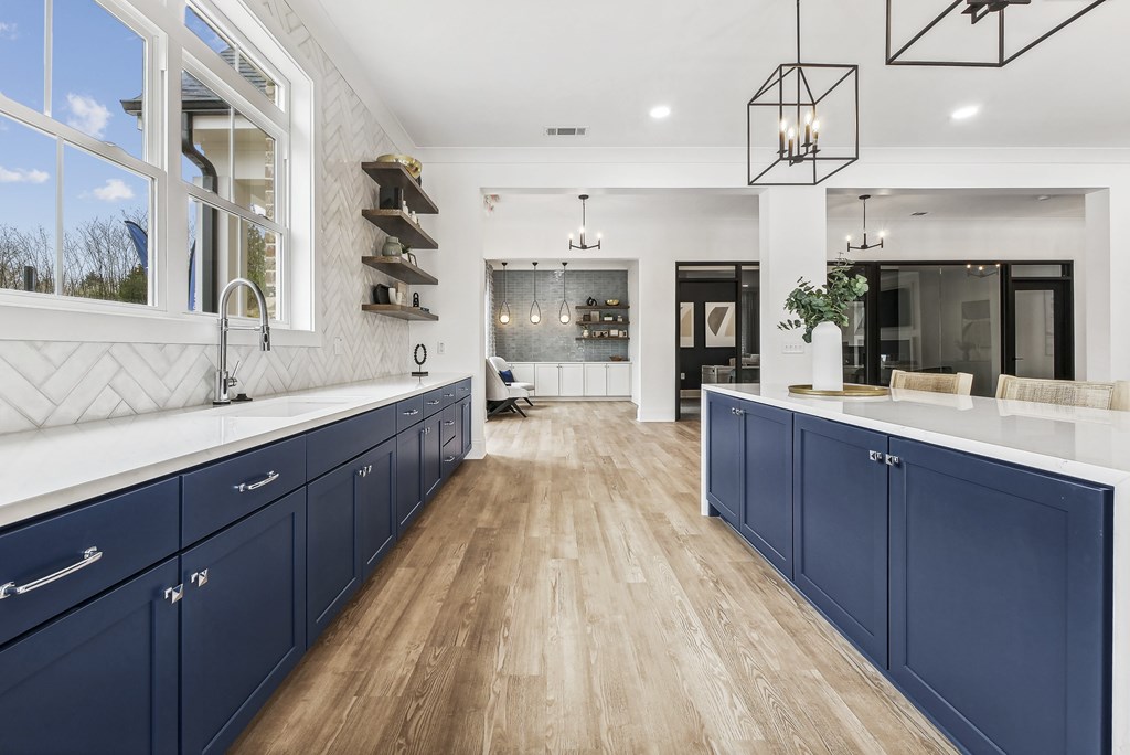 a large kitchen with blue cabinets and white counter tops
