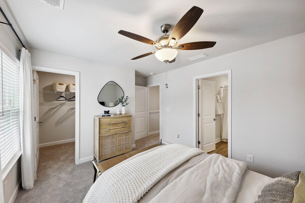 a bedroom with a large bed and a ceiling fan
