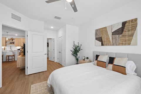A bedroom with a large bed and a ceiling fan.