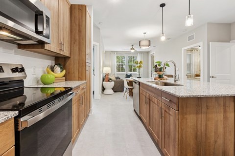 A modern kitchen with wooden cabinets and a black stove top oven.