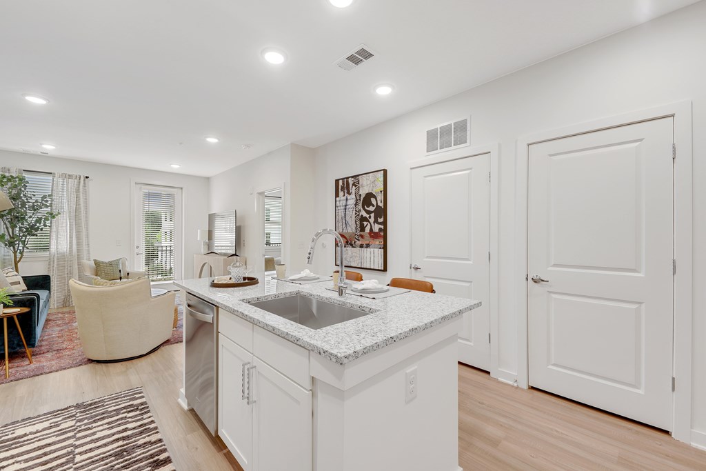 a white kitchen with a sink and a counter top