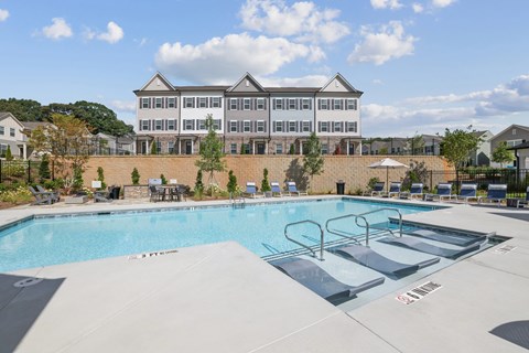 A large swimming pool in front of a multi-story building.