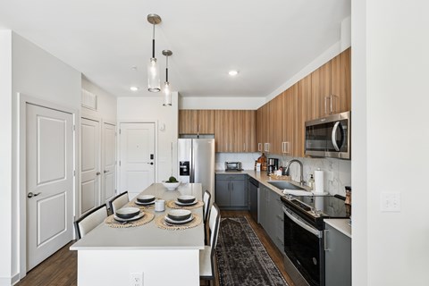 A modern kitchen with a dining table set for two.