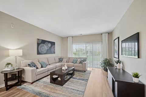 A living room with a couch, a coffee table, and a painting on the wall.