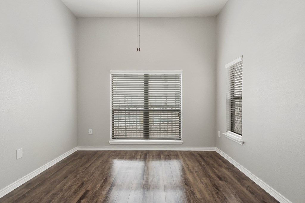 an empty room with wood floors and a window
