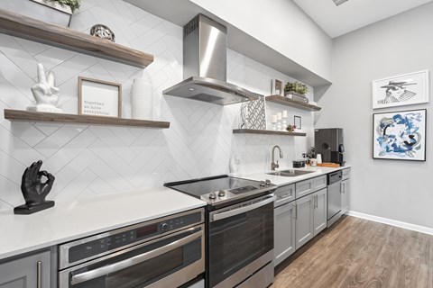 A modern kitchen with a black oven and wooden shelves.
