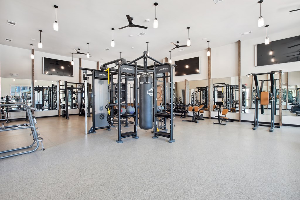 a gym with weights and other exercise equipment in a large room