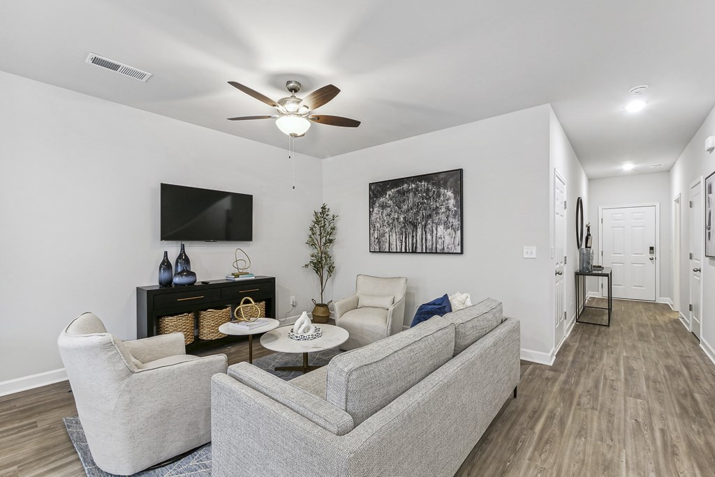 a living room with couches and a ceiling fan