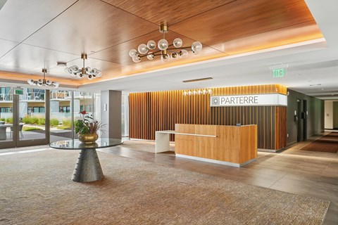 A reception area with a wooden counter and a sign that says "PARTERRE".