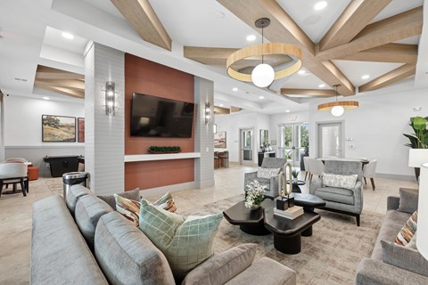 A modern living room with a grey sofa set and a wooden ceiling.