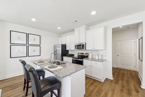 A kitchen with white cabinets and a granite countertop.