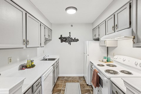 A kitchen with white appliances and a white counter top.