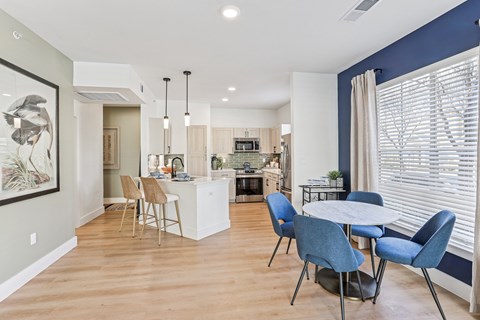 A modern kitchen with a dining table and chairs.