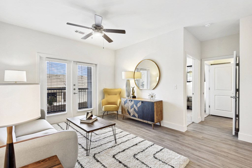 a living room with white walls and a ceiling fan