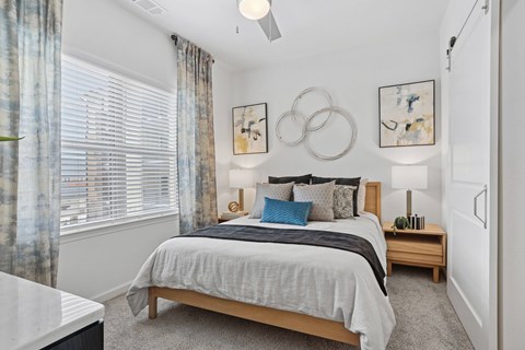 A bedroom with a large bed and a ceiling fan.