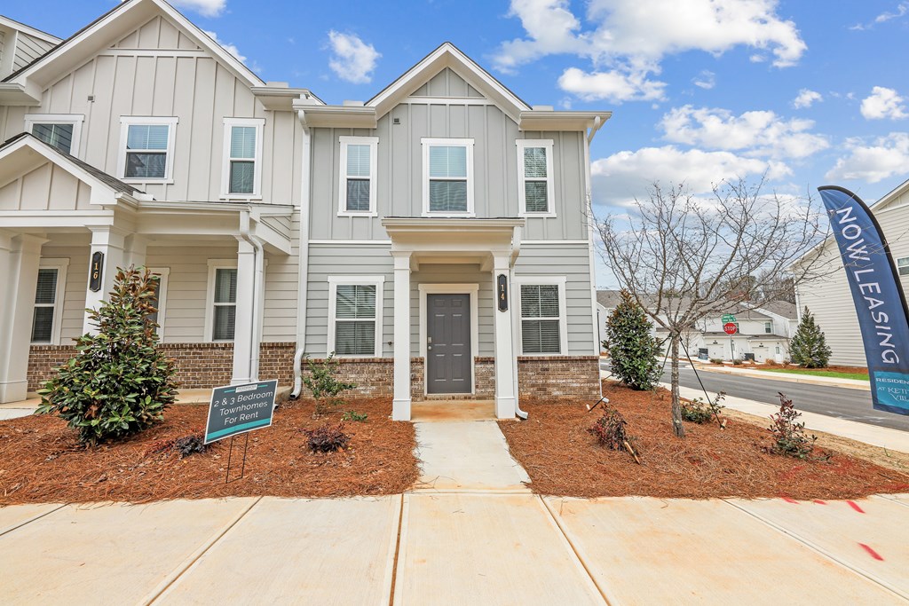 a white house with a sidewalk in front of it