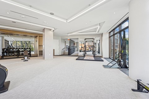 A spacious gym with a variety of equipment and a large mirror on the wall.