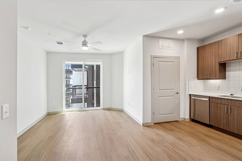 A spacious room with wooden floors and a ceiling fan.