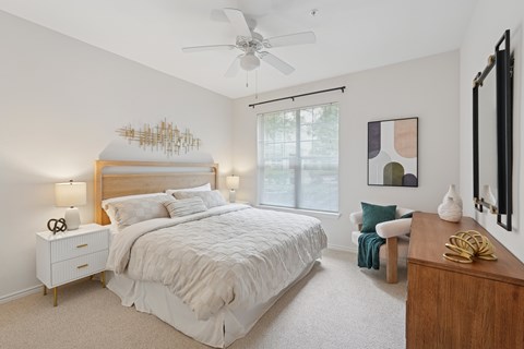 A bedroom with a large bed and a ceiling fan.