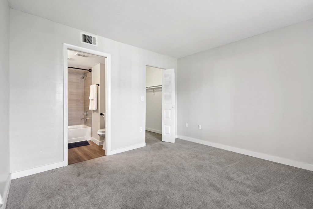 an empty room with a carpeted floor and a bathroom