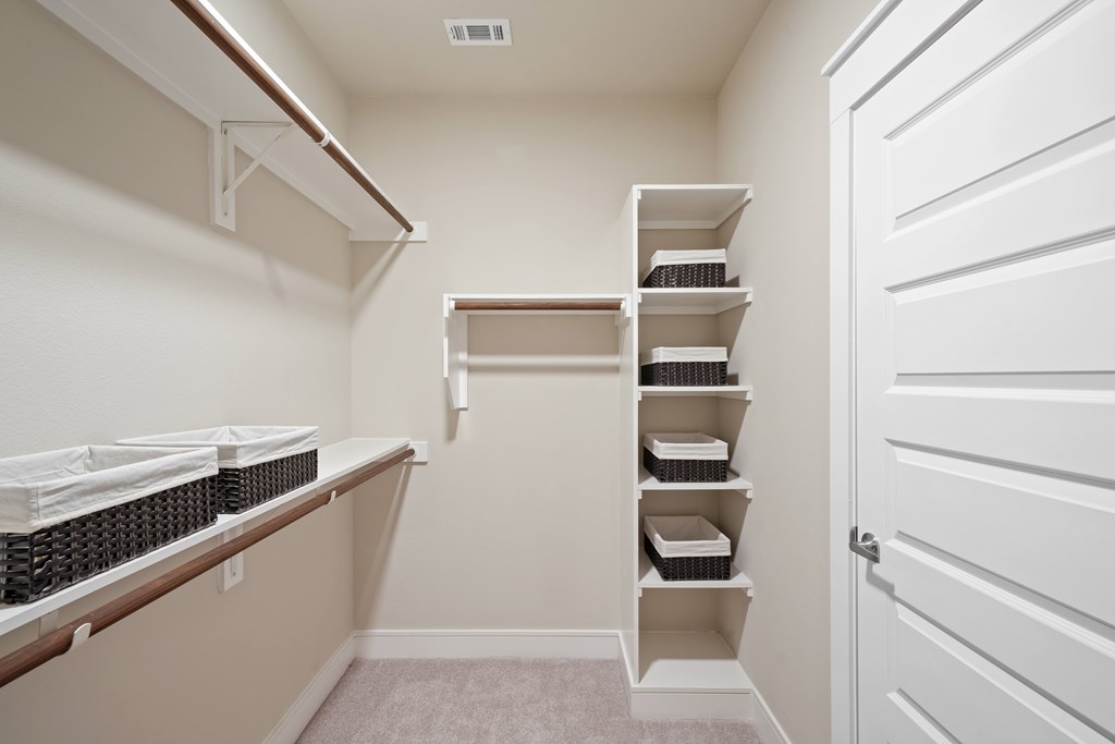 a spacious walk in closet with shelves and baskets
