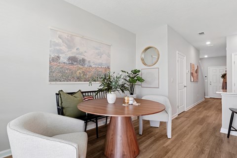 A dining room with a round table and chairs.