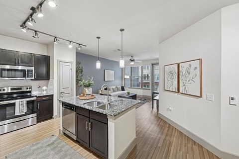 A modern kitchen with dark wood cabinets and stainless steel appliances.