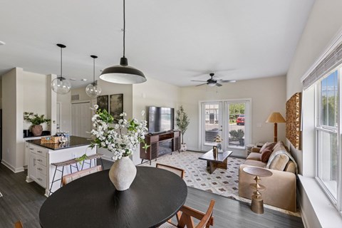 A modern kitchen with a black table and a ceiling fan.