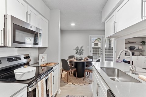 A modern kitchen with a dining table set for two.