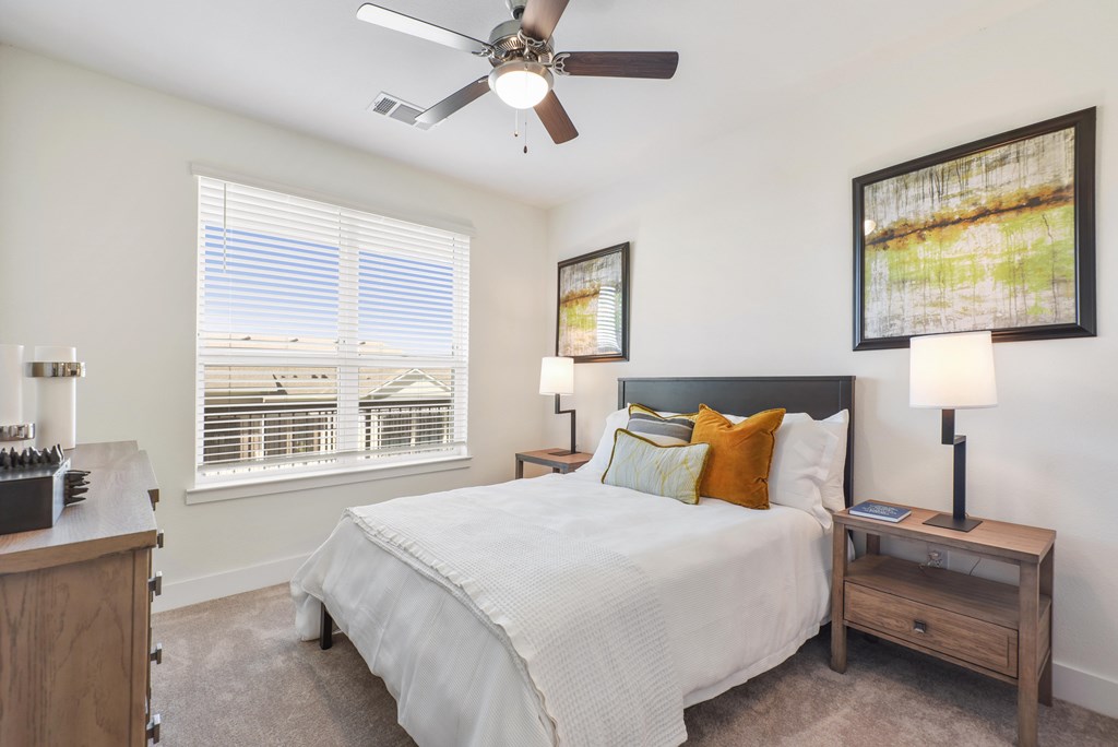 a bedroom with a large bed and a ceiling fan
