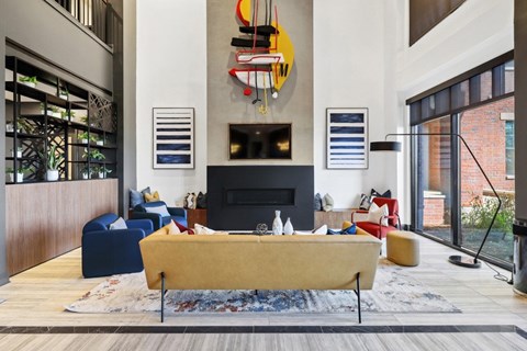 A living room with a yellow sofa and a fireplace.