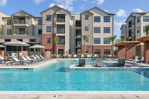 A large swimming pool in front of apartment buildings.
