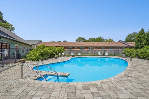 A small pool surrounded by a brick patio.