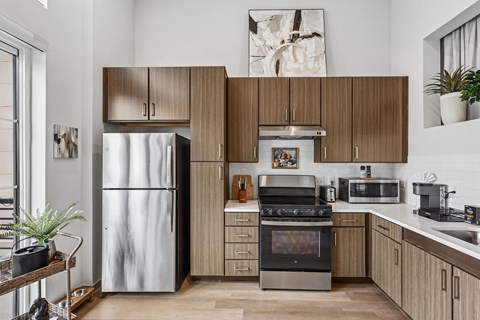 A modern kitchen with a stainless steel refrigerator and wooden cabinets.