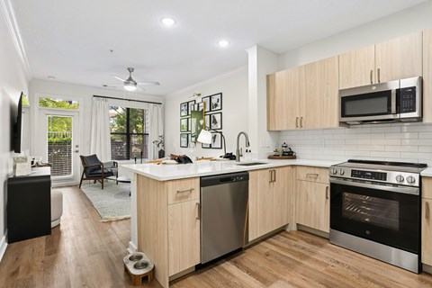 A modern kitchen with wooden cabinets and stainless steel appliances.