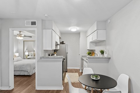 A modern kitchen with a dining table and chairs.