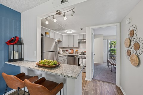A kitchen with a table and chairs.